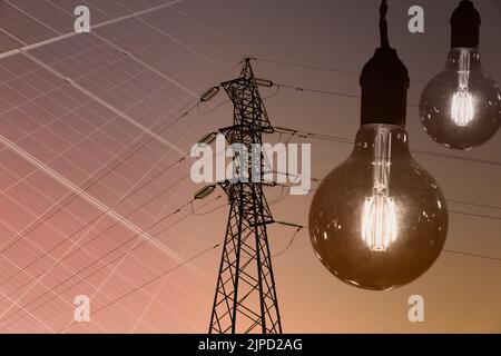 Electricity transmission tower silhouetted against blue sky at dusk Stock Photo