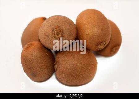 Chilean kiwifruit, Chinese gooseberry is the edible berry of several species of woody vines in the genus Actinidia isolated on white background, Kiwi Stock Photo