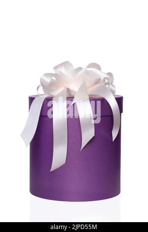 Purple round box with a white bow on an isolated white background. Holiday concept. Stock Photo