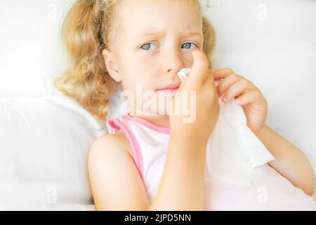 The child himself blows snot into a napkin. Stock Photo