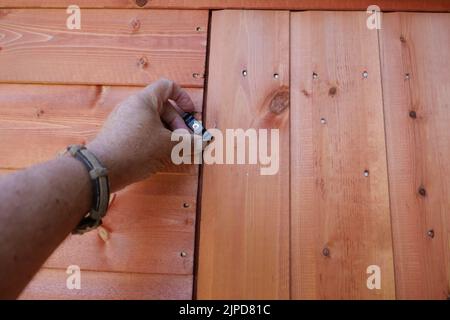POV hand opening or closing a new wooden shed door Stock Photo