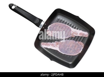 Rashers or sliced raw bacon placed in a griddle frying pan. Isolated on white shot from above cut out Stock Photo