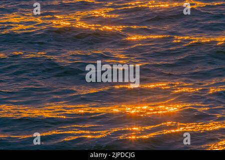 Beautiful sunset over the sea, abstract background of water with sun reflections Stock Photo