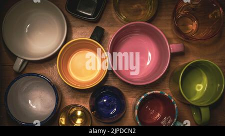 Home still life with cups and glasses of different materials and colors with contrasting light Stock Photo