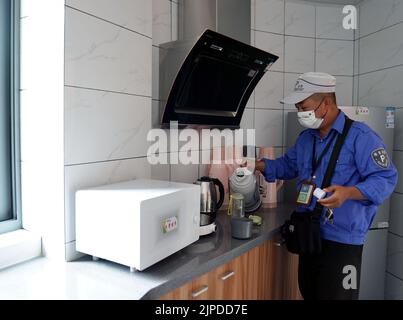 Shanghai, China's Shanghai. 16th Aug, 2022. A road parking attendant takes drinking water at a rest station in Hongkou District, east China's Shanghai, Aug. 16, 2022. The hot weather in Shanghai this summer has brought severe challenges to outdoor work. Recently, on Sanhe Road of Hongkou District, a newly opened rest station has provided a 'sunshade' for nearby sanitation, garden, municipal and other outdoor workers. Credit: Liu Ying/Xinhua/Alamy Live News Stock Photo