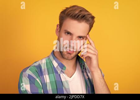 Being in deep thought. Young man with thoughtful face. Thoughtful guy yellow background Stock Photo