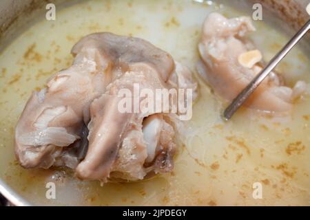 Selective focus of an Arabic Egyptian cuisine of kawareh soup ( trotters soup ) that is full of collagen and Gelatin, cooked cow feet in a cooking pot Stock Photo