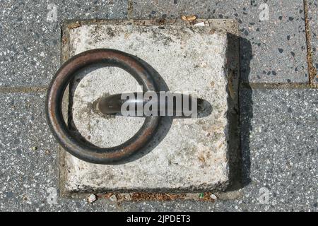 Old mooring post, consisting of a heavy steel ring, alongside a canal in the Netherlands. Abstract pattern of circle and rectangle Stock Photo