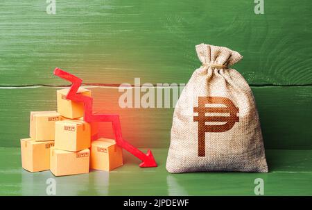 Philippine peso money bag with boxes and down arrow. Income decrease, slowdown and decline of economy. Low sales. Production decline. Reduced transpor Stock Photo