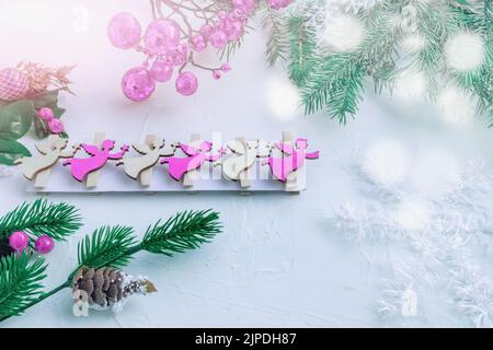 Pine branches, Christmas tree toys and figures of flying angels on wooden clothespins in a Christmas card. Christmas background with a copy space Stock Photo