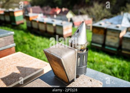 Bee smoker and beehives at background. Apiary Stock Photo