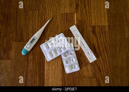 positive corona swipe test showing two bars for Covid 19 infection along with medication and clinical thermometer Stock Photo