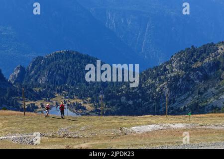CHAMROUSSE, FRANCE, August 11, 2022 : Hikers on the paths over lac Achard, a famous destination for hikers in Chamrousse mountain resort Stock Photo