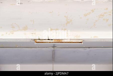 The fluorescent tube on the concrete ceiling of the large warehouse, front view with the copy space. Stock Photo
