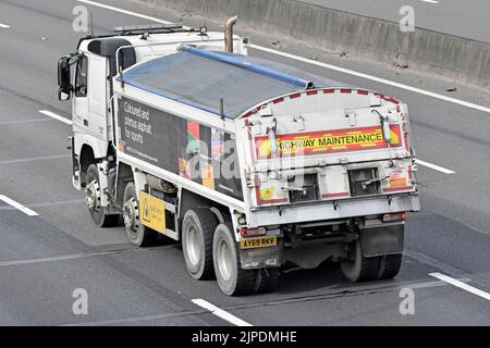 Back & side aerial covered Highway Maintenance tipper lorry truck with Tarmac business name supplying coloured porous asphalt driving UK motorway road Stock Photo