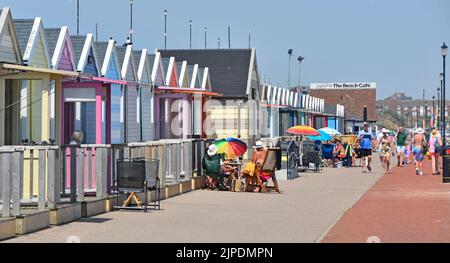 July holidays people & seaside Beach Huts sunny blue sky day on Lower Esplanade Gorleston-on-Sea resort Great Yarmouth Norfolk East Anglia England UK Stock Photo