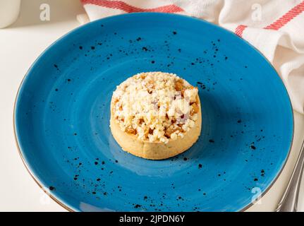 Freshly baked single portion apple pie on a blue porcelain plate Stock Photo