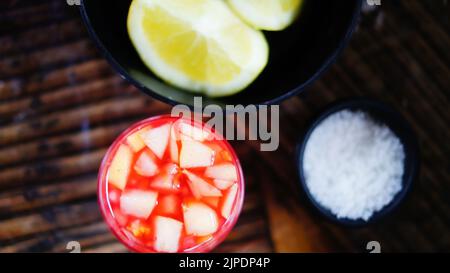 selective approach, alcoholic beverage of tequila, apple and pineapple, lemon and salt to drink with tequila, in a glass Stock Photo