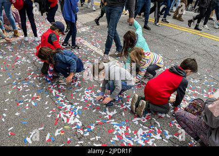 ATLANTA, GA - NOVEMBER 5:  Kids scoop up confetti off the street following the Atlanta Braves World Series championship parade, on November 5, 2021. Stock Photo