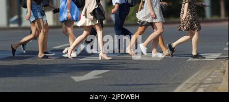 A crowd of pedestrians crossing street in the city, people walking in the street. Local, selective partial motion blur Stock Photo