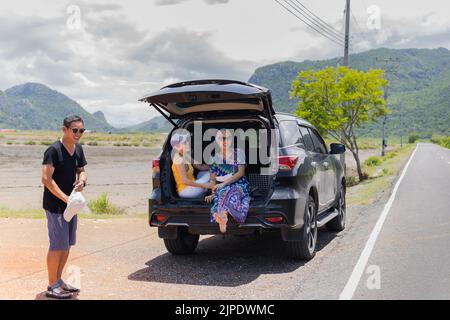 Three best friends enjoying traveling in the car on a road trip. Stock Photo