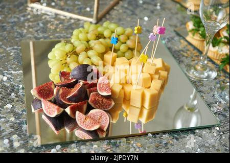 Fruits and cheese on a mirror plate for snack Stock Photo