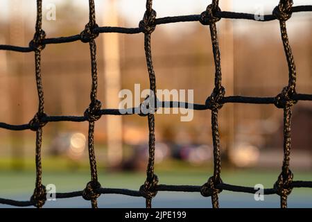 Late afternoon close up photo of new outdoor tennis court net. Stock Photo