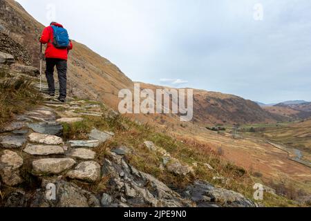 Hiker walking up a mountain path towards Styhead Tarn in Borrowdale, Lake District National Park, Cumbria Stock Photo