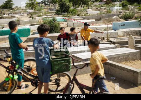 Gaza, Palestine. 17th Aug, 2022. Relatives of five Palestinian children killed during the recent fighting between Israel and Gaza gather near their graves, in Jabalia in the northern Gaza Strip. Israel has admitted to killing five Palestinian children in an air raid on the Fallujah cemetery in the town of Jabalia, in the northern Gaza Strip, on August 7th, after initially claiming they were killed as a result of a missile fired by Islamic Jihad, Israel's Haaretz newspaper reported. (Photo by Mahmoud Issa/SOPA Images/Sipa USA) Credit: Sipa USA/Alamy Live News Stock Photo