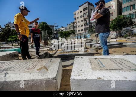 Gaza, Palestine. 17th Aug, 2022. Relatives of five Palestinian children killed during the recent fighting between Israel and Gaza gather near their graves, in Jabalia in the northern Gaza Strip. Israel has admitted to killing five Palestinian children in an air raid on the Fallujah cemetery in the town of Jabalia, in the northern Gaza Strip, on August 7th, after initially claiming they were killed as a result of a missile fired by Islamic Jihad, Israel's Haaretz newspaper reported. (Photo by Mahmoud Issa/SOPA Images/Sipa USA) Credit: Sipa USA/Alamy Live News Stock Photo