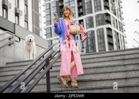 Stylish woman with phone at modern residential area Stock Photo