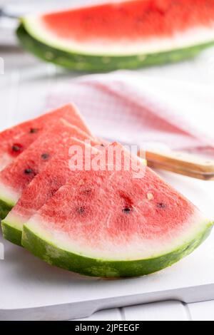 Slices of red watermelon on a cutting board. Stock Photo