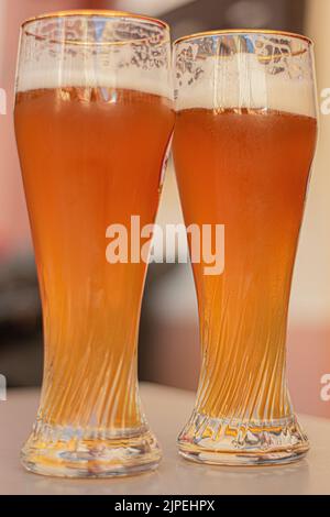Two beer glasses on a white table Stock Photo