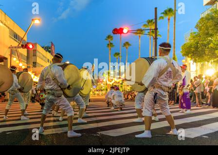 Tokushima, Japan - August 12, 2022: Taiko drum group wearing traditional white clothing at Awaodori festival as night falls Stock Photo