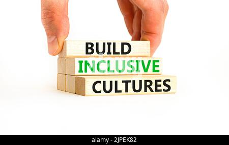 Build inclusive cultures symbol. Concept words Build inclusive cultures on wooden blocks. Businessman hand. Beautiful white background. Business build Stock Photo