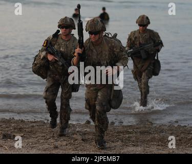Soldiers from 2nd Brigade Combat Team Strike 101st Airborne Division (Air Assault), 18th Airborne Corps, move out of the water and onto the beach during a FORSCOM Best Squad Competition water insertion event on Fort Hood, Texas, August 16, 2022. Each of these events are designed to test the physical and mental toughness along with the lethality of each squad to see which squad will represent FORSCOM at the Best Squad of the Army competition that will take place at Ft. Bragg. Stock Photo