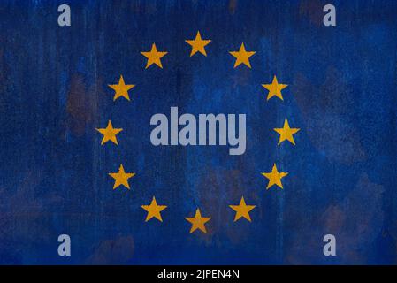 Full frame front view photo of a weathered flag of Europe (EU, European Union) painted on a rusty, grunge and dirty wall. Stock Photo