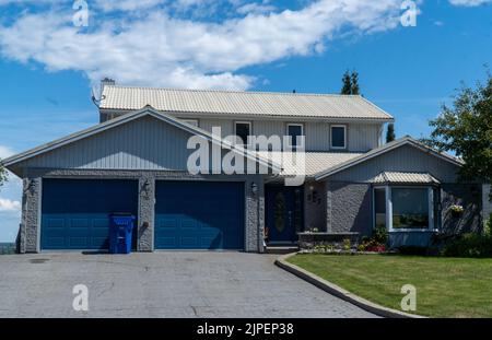 Custom built luxury house with nicely trimmed and landscaped front yard, lawn in a residential neighborhood. Stock Photo