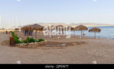 Greece Empty beach. chairs and closed sun umbrellas on the beach in Greece. Stock Photo