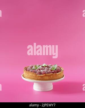cheesecake with fresh raspberry on cake stand on pink background, free copy space Stock Photo