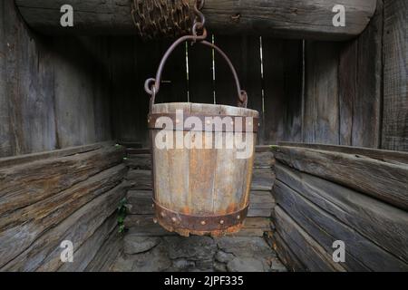 Old wooden bucket in a well close-up Stock Photo