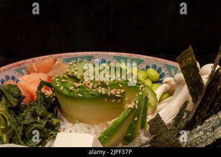 Avocado salad with sesame seeds, dried nori seaweed flakes, white rice and mushrooms Stock Photo