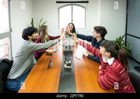 Cheerful office workers giving high five to colleagues Stock Photo