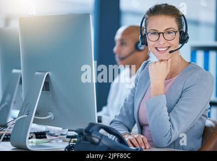 Call center agent, telemarketing employee or customer service worker is happy and smiling in the office. Portrait of a caucasian female sales Stock Photo