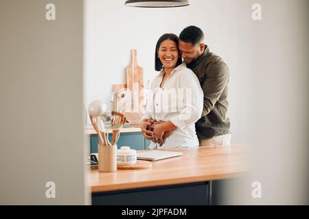 Hugging, happy and excited couple spending quality time together and relaxing at home. Loving, relaxed and affectionate African lovers embracing Stock Photo