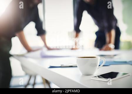Its one busy work day. two unrecognizable businessmen working through business plans together inside of the office. Stock Photo