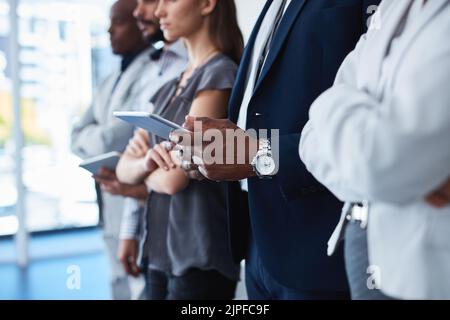 When in doubt, use technology to upgrade your business. unrecognizable corporate businesspeople using different devices in an office. Stock Photo