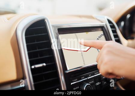 Looking for a shortcut. an unrecognizable woman using her GPS while driving. Stock Photo