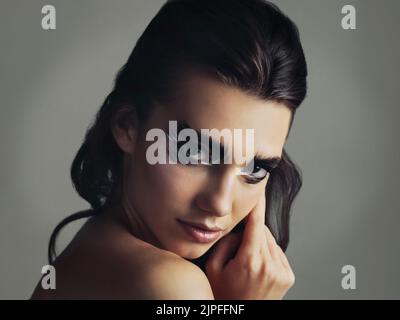 Keep calm and be different. Studio shot of an attractive young woman wearing bold eye makeup. Stock Photo