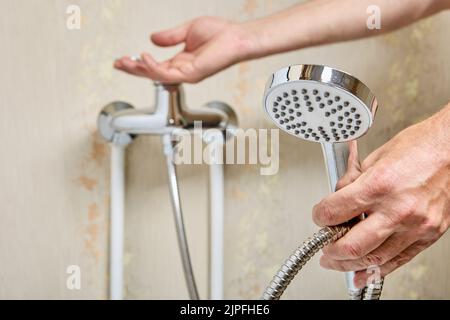 Shower head on flexible hose in bathroom, plumber connected hose to home plumbing. Stock Photo